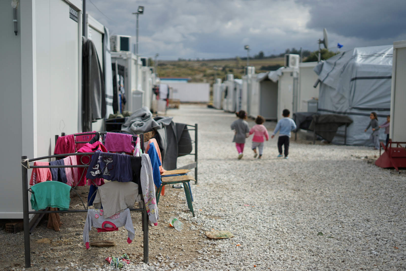 Hero image of children walking by temporary homes.